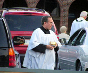 Priests distrubing Communion in parking lot